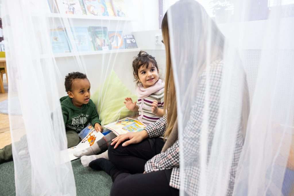 Pedagog sitter med barn i en lugn vrå