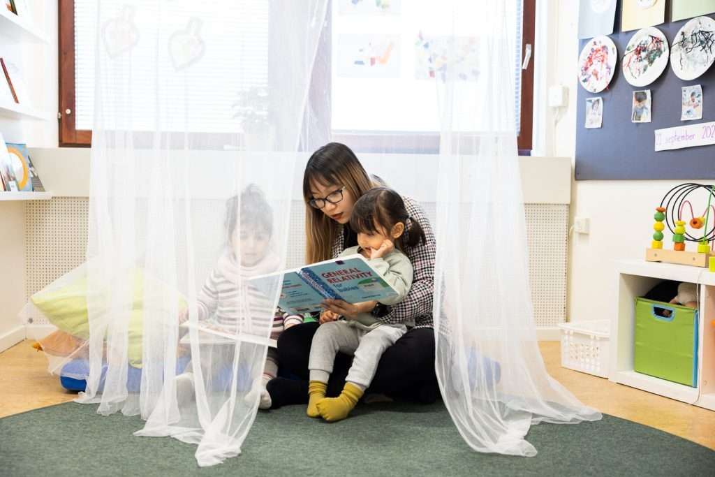Pedagog läser bok tillsammans med ett barn