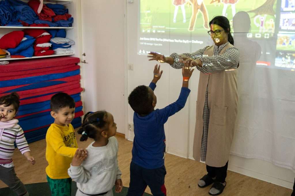 Pedagog leker med barn inomhus